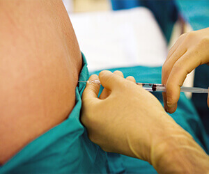 A patient receiving an epidural injection in their lower back. 